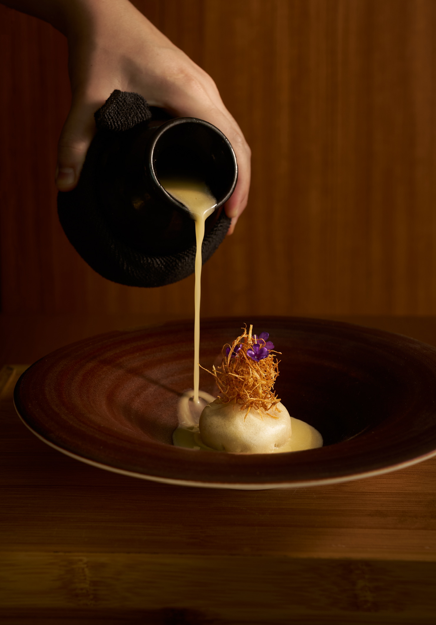 Chef pouring sauce at Friend's Table Chiang Mai