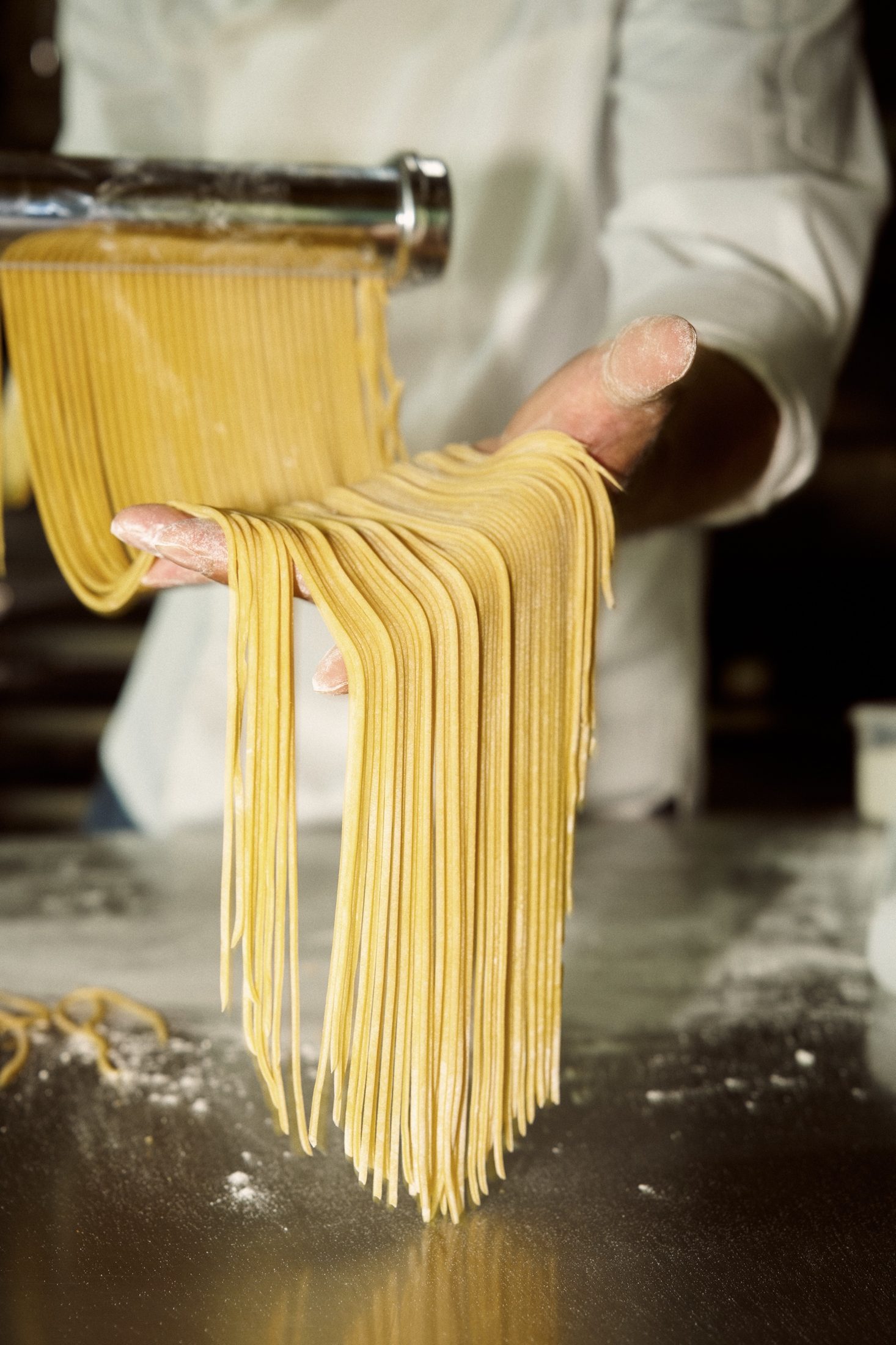 Fresh egg capellini coming off the pasta machine