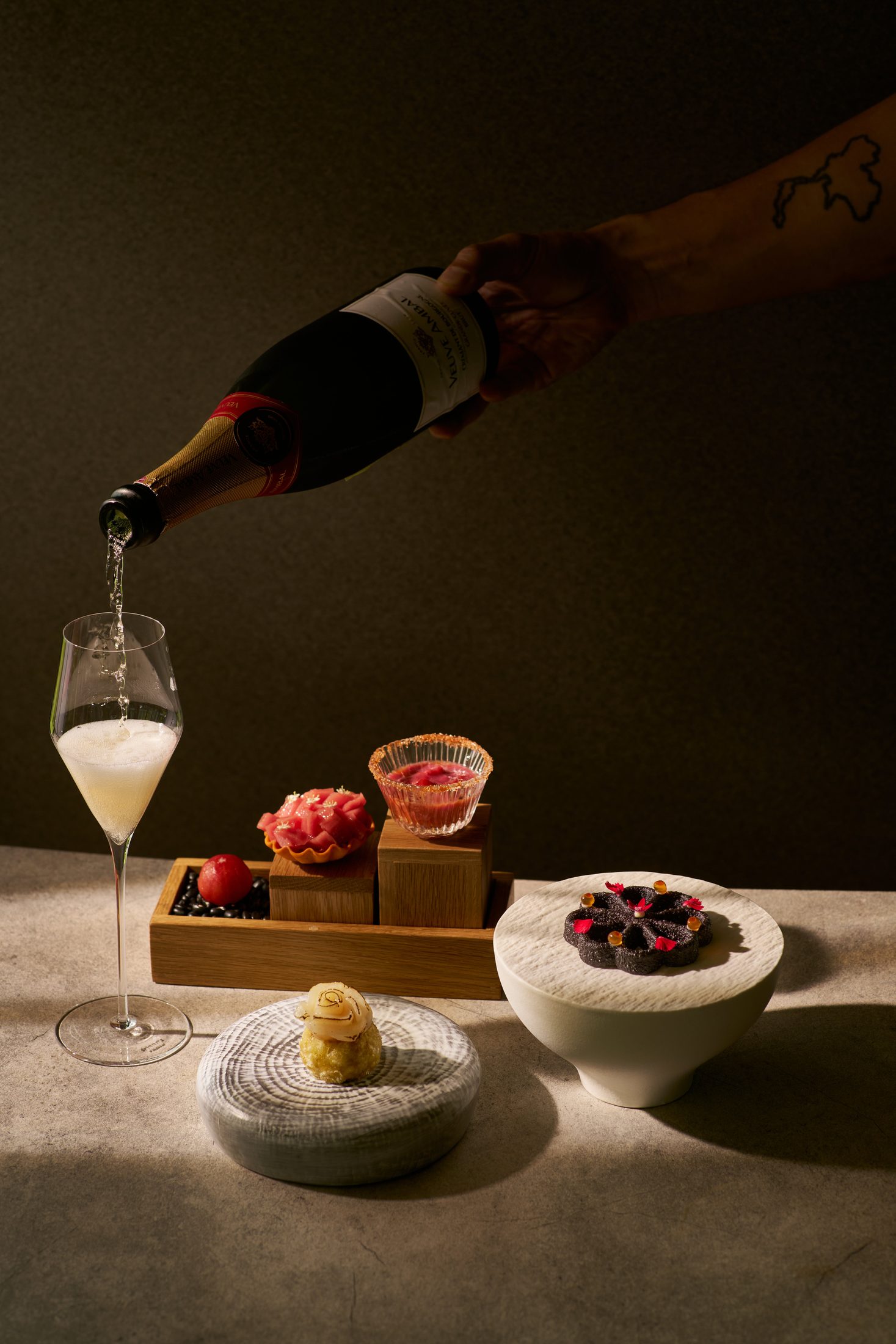 Opening bites — tokyo rosette and hotate arancini, with champagne poured alongside